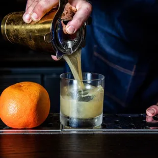 a bartender pouring a drink into a glass