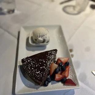 a piece of chocolate cake with berries and ice cream