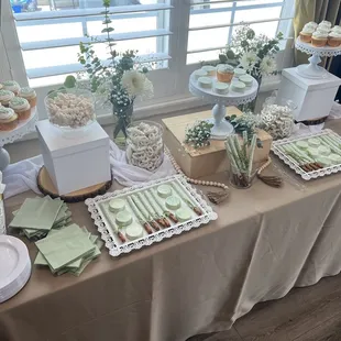Dessert table with cupcakes, gummy bears, chocolate covered pretzels, and chocolate covered Oreos!