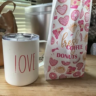 a coffee cup and a bag of donuts