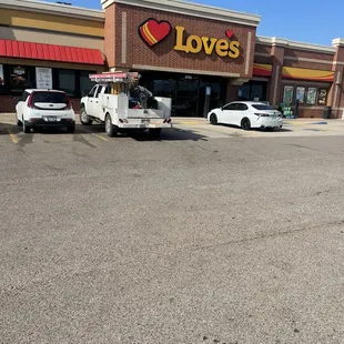 two cars parked in front of a love's store