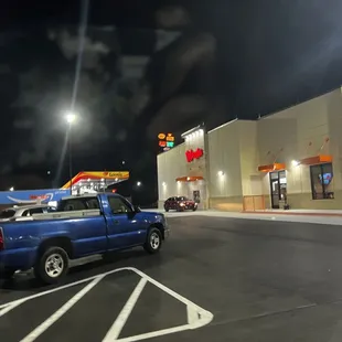 a blue pickup truck parked in front of a store