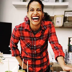 a woman laughing in front of a cake