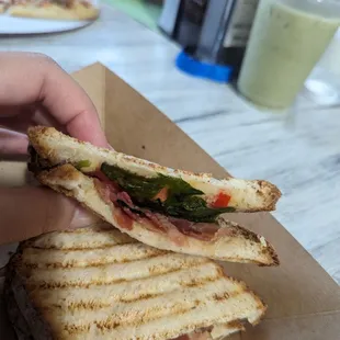 a hand holding a sandwich