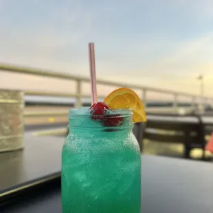 a blue drink with a straw