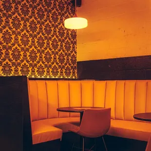 a corner booth with a table and chairs