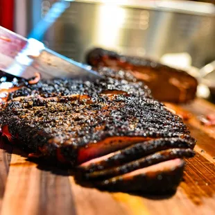 a steak being sliced on a cutting board