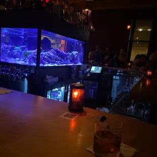 a bar with a fish tank in the background