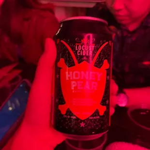 a person holding a can of honey pops