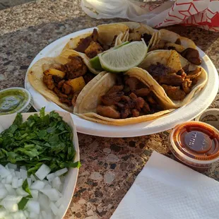 Al pastor tacos with a side of cilantro and onion