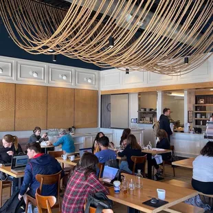 a group of people sitting at tables in a coffee shop