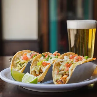 a plate of tacos and a glass of beer