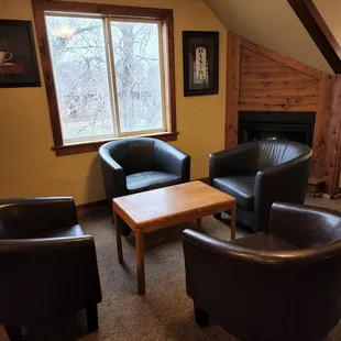 a living room with leather chairs and a coffee table