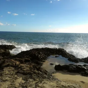 Waves crashing against rocks on shore.