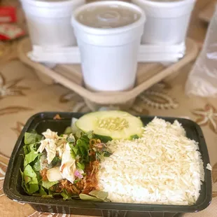 a meal of rice, salad, cucumber, and chicken