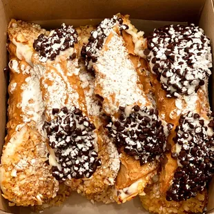 a box of desserts with powdered sugar on top