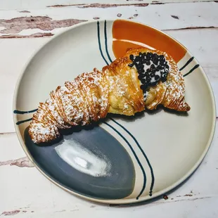 Lobster tail pastry filled with ricotta cream and encrusted with chocolate chips.