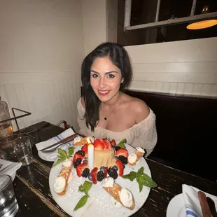 a woman sitting at a table with a plate of food