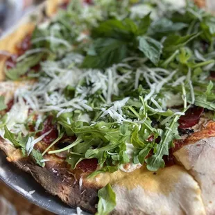 a pizza topped with greens and cheese