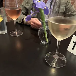 a woman sitting at a table with a glass of wine