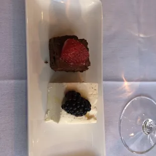 a plate of desserts and a glass of wine