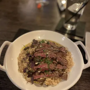 a bowl of beef and rice on a table