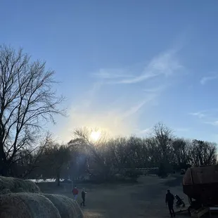 the sun setting over a hay bale