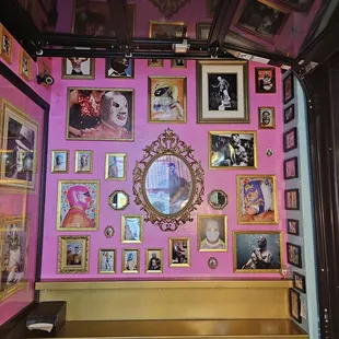 a pink wall with pictures on it