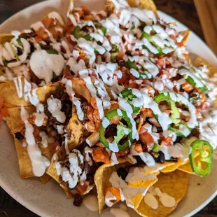 Bulgogi Nachos. $15.99. Giant-size nachos with Korean BBQ beef, pico, kimchi, cheese, crema, jalapenos, black beans.