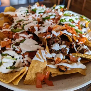 Bulgogi Nachos. $15.99. Giant-size nachos with Korean BBQ beef, pico, kimchi, cheese, crema, jalapenos, black beans.