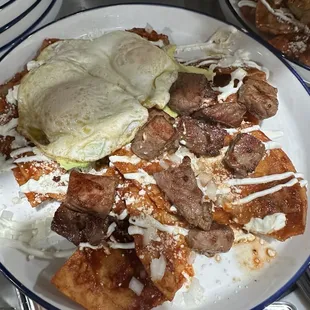 Red chilaquiles with eggs and ribeye steak