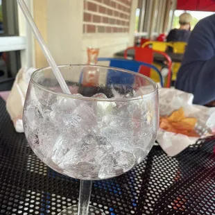 a glass of water with ice and a straw