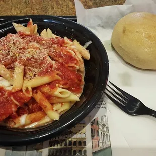 a plate of pasta and a roll