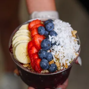 a person holding a bowl of fruit