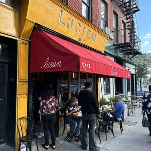 a group of people sitting outside a restaurant