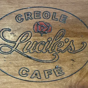 Restaurant's name carved into the wooded bar table