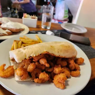 a plate of fried shrimp sandwich and french fries