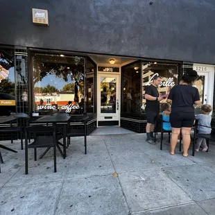 a group of people standing outside of a restaurant