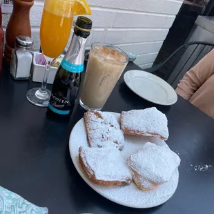 a plate of powdered sugared pastries on a table