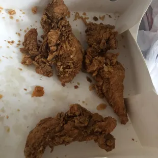 Three old, dry chicken tenders at the bottom of the box.