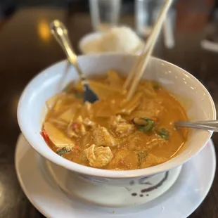 a bowl of soup with chopsticks