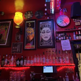 a wall of liquor bottles and a clock