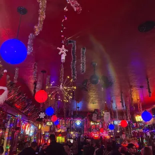 a brightly lit bar with a rainbow in the ceiling