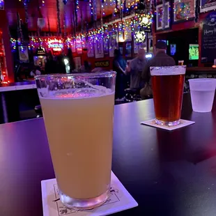 two glasses of beer on a bar