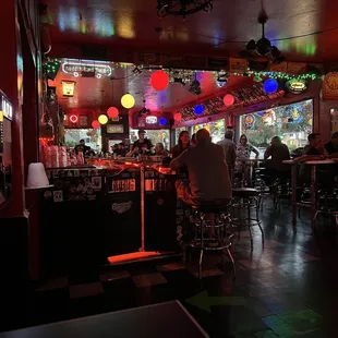 people sitting at tables in a bar