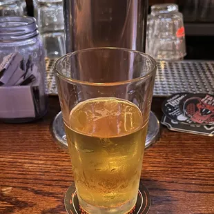 a glass of beer on a bar