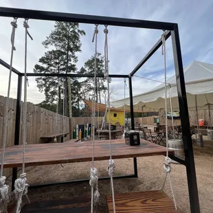 a wooden swing set with ropes