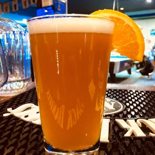 a glass of beer with an orange slice