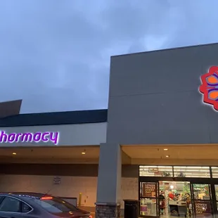 a pharmacy store with a car parked in front of it
