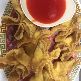 a plate of fried food with a bowl of ketchup